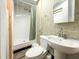 Compact basement bathroom with shower, toilet, and pedestal sink with medicine cabinet at 3323 Baugh St, Raleigh, NC 27604