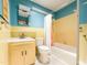 Bathroom featuring blue and yellow tile, shower with curtain, toilet, and vintage sink at 3323 Baugh St, Raleigh, NC 27604