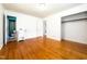 Bright bedroom with hardwood floors, white walls, and closet with rack with adjacent bathroom at 3323 Baugh St, Raleigh, NC 27604