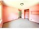 Bedroom featuring neutral carpet, light pink walls, closet with rack, and a window with natural light at 3323 Baugh St, Raleigh, NC 27604