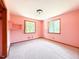Bedroom featuring two windows, wall to wall carpeting, and pink painted walls at 3323 Baugh St, Raleigh, NC 27604