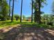 Exterior view of a charming home nestled among mature trees on a sunny day at 3323 Baugh St, Raleigh, NC 27604