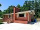 Single-story brick home featuring white trim, a brick chimney, and a freshly painted porch at 3323 Baugh St, Raleigh, NC 27604
