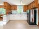 U-shaped kitchen with black fridge, wood paneling, and breakfast bar at 3323 Baugh St, Raleigh, NC 27604