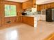 Bright kitchen featuring wood paneling, breakfast bar and a black refrigerator at 3323 Baugh St, Raleigh, NC 27604