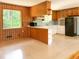 Spacious kitchen with breakfast bar, wood paneling and an adjacent living area at 3323 Baugh St, Raleigh, NC 27604