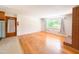 Inviting living room featuring hardwood floors, a brick fireplace, and natural light from a large window at 3323 Baugh St, Raleigh, NC 27604