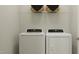 Functional laundry room with modern washer and dryer units, and ample storage space at 335 Tennyson Dr, Garner, NC 27529