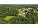 Breathtaking aerial view of a sprawling horse property surrounded by verdant trees and rolling hills at 3511 Corbett Rd, Mebane, NC 27302