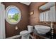 Charming powder room featuring a round window, unique sink, and warm, inviting colors at 3511 Corbett Rd, Mebane, NC 27302