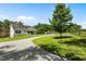 Gravel driveway leading to a white home with a porch and nearby horse stables on a manicured lawn at 3511 Corbett Rd, Mebane, NC 27302