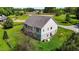 Aerial view of the back of the home with neutral siding, a gray roof, lush green grass, and a partially fenced in yard at 3511 Corbett Rd, Mebane, NC 27302
