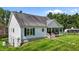 Exterior view of home featuring a porch and basement access on a well-manicured lawn and garden at 3511 Corbett Rd, Mebane, NC 27302