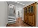 Hallway features hardwood floors, staircase, and hutch with view of the bathroom at 3511 Corbett Rd, Mebane, NC 27302