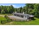 View of a white horse barn with stalls, dark trim, and a gravel area at 3511 Corbett Rd, Mebane, NC 27302