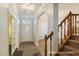 Inviting foyer featuring dark hardwood floors, a staircase, and a doorway leading to the front entrance at 3610 Long Ridge Rd, Durham, NC 27703
