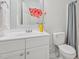 Well-maintained bathroom with a vanity and toilet, complemented by colorful flower accents at 3973 Volkswalk Pl, Raleigh, NC 27610