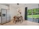Cozy dining area with natural lighting, hardwood floors, and stainless steel refrigerator at 3973 Volkswalk Pl, Raleigh, NC 27610