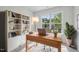 Bright home office with built-in shelving, a large window, and a wooden desk at 3973 Volkswalk Pl, Raleigh, NC 27610