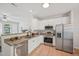 Bright kitchen with stainless steel appliances, white cabinets, hardwood floors, and open layout at 3973 Volkswalk Pl, Raleigh, NC 27610