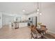 Open-concept kitchen and dining area featuring stainless steel appliances, white cabinets, and hardwood floors at 3973 Volkswalk Pl, Raleigh, NC 27610