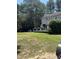 Large backyard with a spacious deck featuring outdoor furniture, tall mature trees, and a well-maintained lawn at 4117 Mangrove Dr, Raleigh, NC 27616