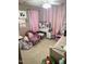 Bedroom with pink walls and decorative touches, including a bed, desk, and comfortable seating at 4117 Mangrove Dr, Raleigh, NC 27616