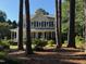 Two-story home with a welcoming front porch and classic blue shutters, viewed through a wooded landscape at 4117 Mangrove Dr, Raleigh, NC 27616