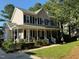 Charming two-story home with a welcoming front porch, beautiful landscaping, and classic blue shutters at 4117 Mangrove Dr, Raleigh, NC 27616