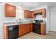 Well-lit kitchen with stainless steel appliances, granite countertops, and wood cabinets at 413 Hallie Long Ln, Burlington, NC 27217
