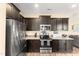 Kitchen view showcasing stainless appliances, granite countertops, and dark wood cabinets at 50 N Nolan Park Dr, Selma, NC 27576