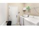 Bright laundry room featuring a white washer and dryer, a door, and shelving at 50 N Nolan Park Dr, Selma, NC 27576