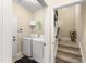 A neat laundry room with modern washer and dryer, adjacent to a carpeted staircase at 50 N Nolan Park Dr, Selma, NC 27576