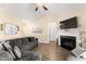 Bright living room with a fireplace, vaulted ceiling, ceiling fan, and cozy gray sectional sofa at 50 N Nolan Park Dr, Selma, NC 27576