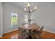 Bright dining area with large windows, featuring hardwood floors and a modern lighting fixture at 513 Moultonboro Ave, Wake Forest, NC 27587