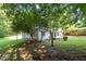 This single-story home features a charming front porch and manicured lawn, framed by mature trees and natural surroundings at 514 Lipscomb Grove Church Rd, Hillsborough, NC 27278