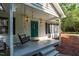 Charming front porch with a swing, a vibrant turquoise door, and decorative details that enhance its curb appeal at 514 Lipscomb Grove Church Rd, Hillsborough, NC 27278