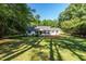 Charming single-story home with a lush green front yard and mature trees offering plenty of shade on a sunny day at 514 Lipscomb Grove Church Rd, Hillsborough, NC 27278