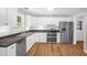Bright kitchen features white cabinets, stainless steel appliances, and wood-look floors at 514 Lipscomb Grove Church Rd, Hillsborough, NC 27278