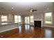 Open-concept living area with hardwood floors, fireplace, and large windows overlooking the backyard at 5491 Silk Hope Gum Springs Rd, Siler City, NC 27344