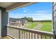 A view from the balcony showing manicured lawn, driveways, and neighboring buildings under a bright blue sky at 555 Forestville Rd, Wake Forest, NC 27587