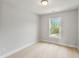 Bright bedroom with neutral walls, carpet, and a window overlooking greenery at 555 Forestville Rd, Wake Forest, NC 27587