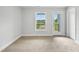Bright room featuring neutral walls, carpet, a window, and door to a private outdoor balcony at 555 Forestville Rd, Wake Forest, NC 27587