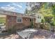 The house back exterior features brick and siding with a deck and mature trees at 612 Locust Ln, Raleigh, NC 27603