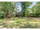 A backyard view features a wooden deck with stairs surrounded by mature trees at 612 Locust Ln, Raleigh, NC 27603