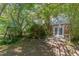 A backyard view features mature trees, a brick exterior, and a set of French doors at 612 Locust Ln, Raleigh, NC 27603