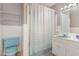 Bathroom with a blue toilet and sink with a shower and wall shelving at 612 Locust Ln, Raleigh, NC 27603