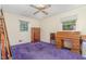Bedroom featuring two windows, purple carpet, and furniture at 612 Locust Ln, Raleigh, NC 27603