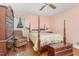 Cozy bedroom with hardwood floors, a four-poster bed, and a recliner at 612 Locust Ln, Raleigh, NC 27603