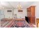 Elegant dining area with hardwood floors, a vintage cabinet, and a chandelier illuminated by natural light at 612 Locust Ln, Raleigh, NC 27603